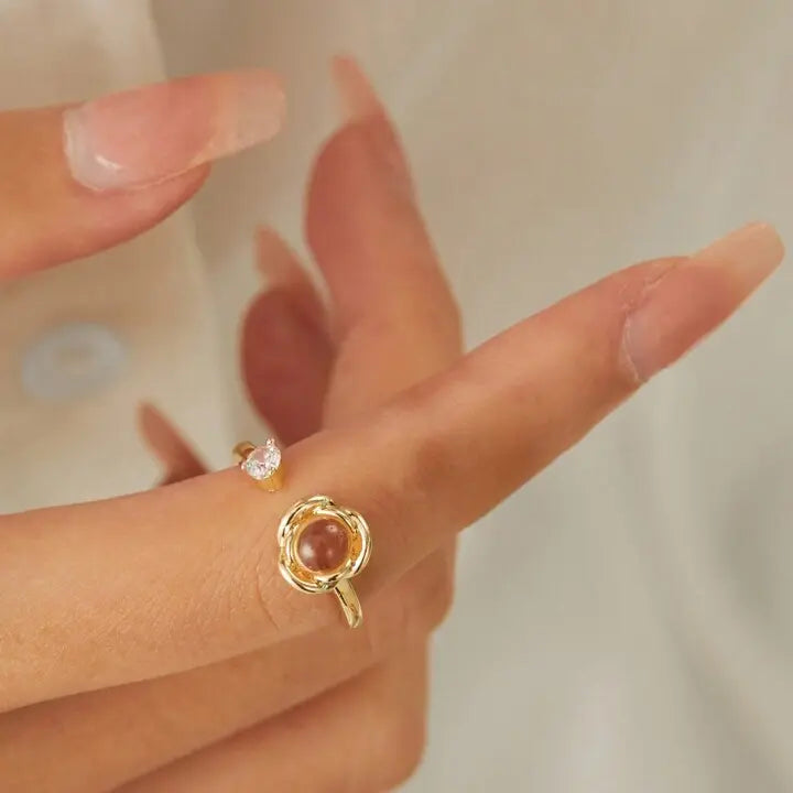 Close-up de anel feminino dourado personalizado no dedo, com pedra central e visual elegante.