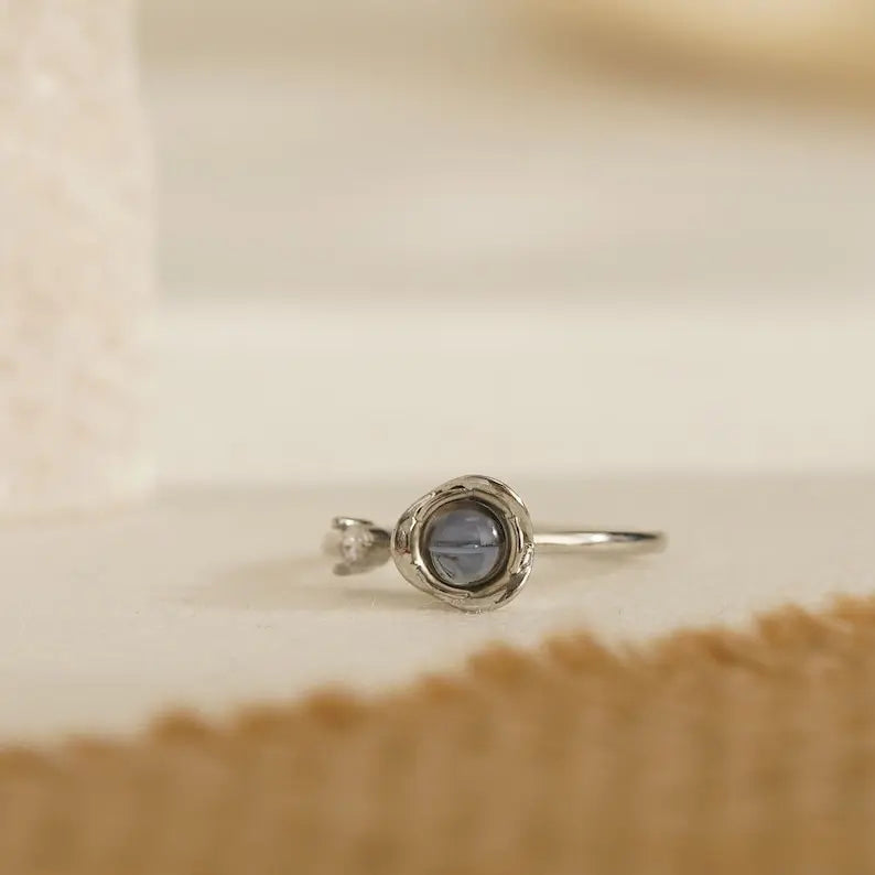 Anel feminino de prata personalizado em close, com aro delicado e base circular para foto.