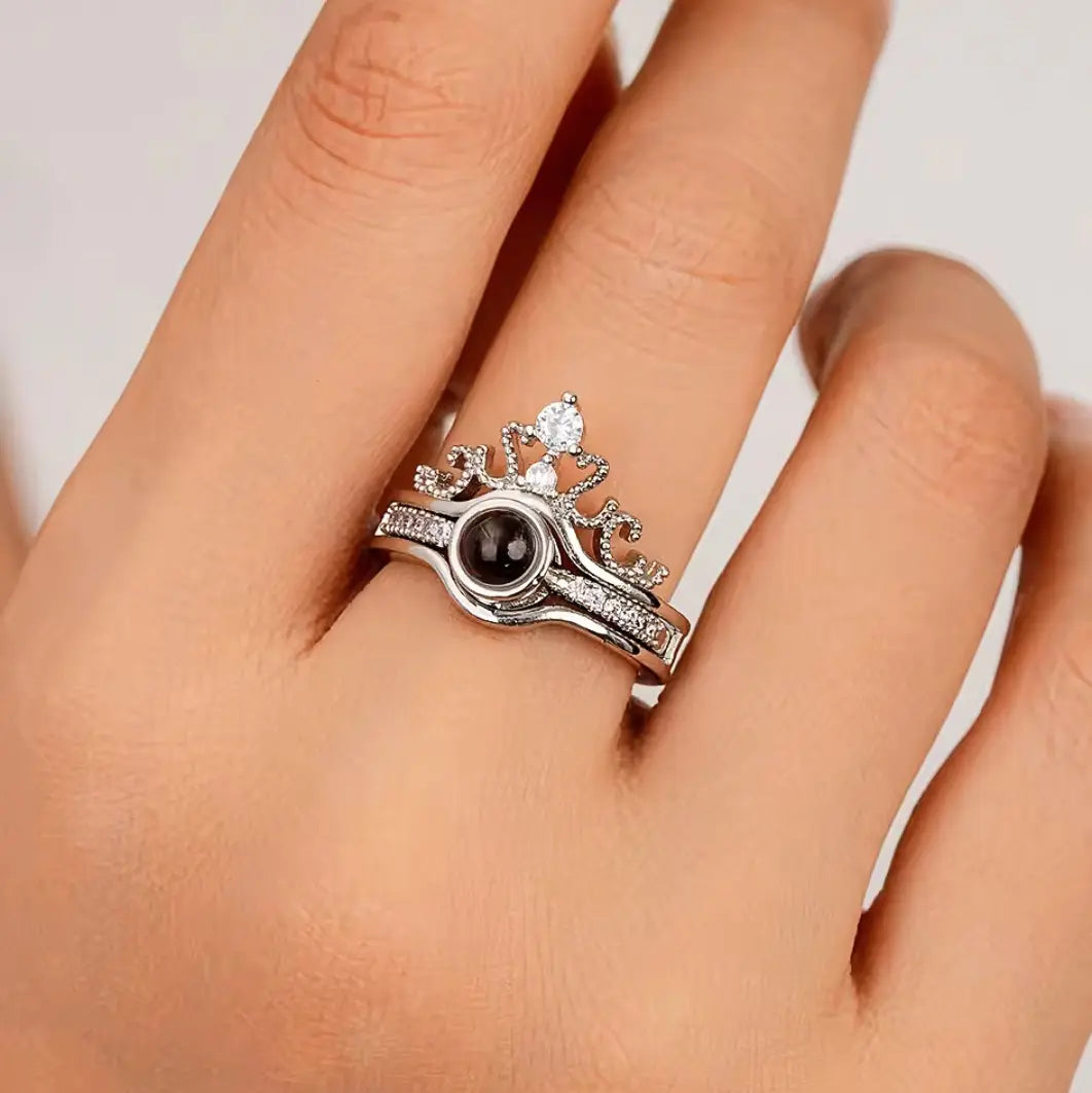 Anel feminino de prata personalizado com foto, usado no dedo da mão, com detalhe de coroa e pedra central.