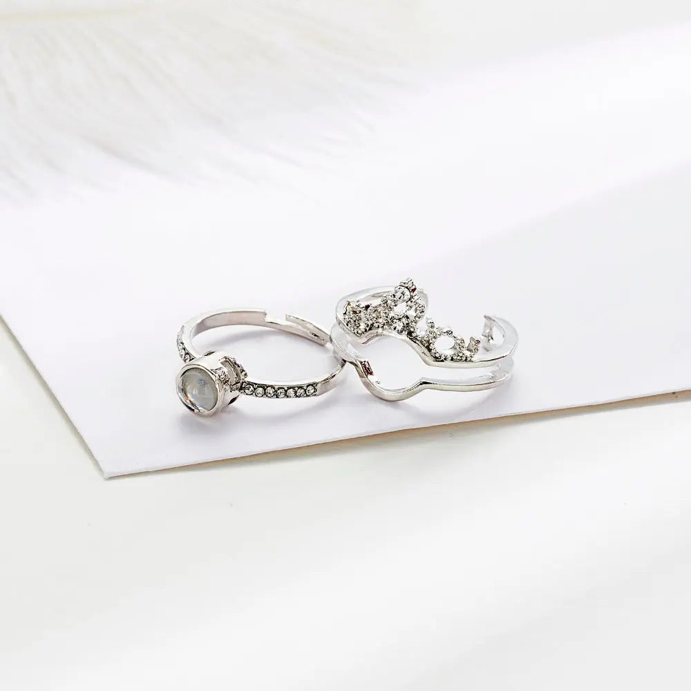 Anel feminino de prata personalizado com pedra redonda e detalhes cravejados sobre fundo claro.