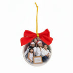 Bola de árvore de Natal personalizada com foto de família e laço vermelho, pendurada por fita dourada.