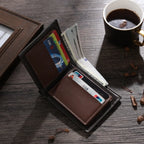 Carteira masculina de couro cinza aberta, com compartimentos para cartões e cédulas, em ambiente com café ao lado.