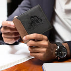 Carteira masculina de couro cinza personalizada com foto, sendo segurada com as duas mãos.