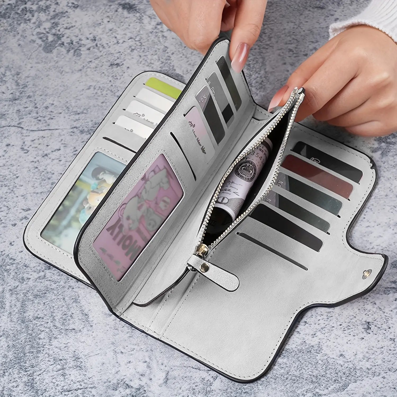 Carteira feminina de couro cinza aberta, com compartimentos para cartões, bolso com zíper e espaço para foto personalizada.
