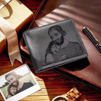 Carteira masculina de couro cinza com gravação personalizada de pai e filha abraçados, mostrada sobre mesa com itens de presente.