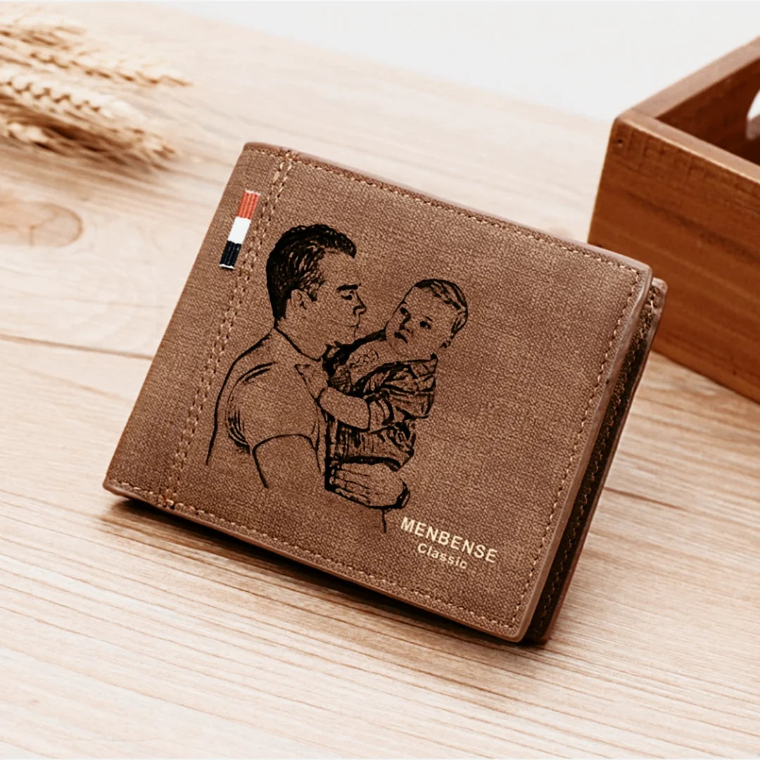 Carteira de couro marrom masculina personalizada apoiada sobre mesa de madeira, com gravação de pai segurando bebê na capa.