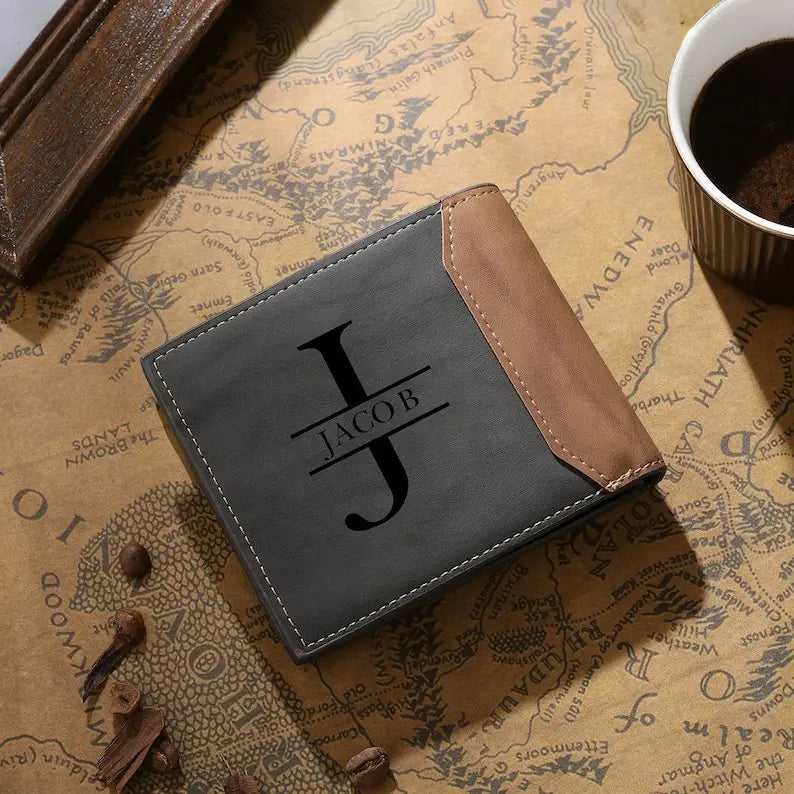 Carteira masculina de couro cinza personalizada com inicial e nome em destaque sobre superfície decorativa.