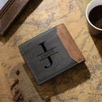 Carteira masculina de couro cinza personalizada com inicial e nome em destaque sobre superfície decorativa.