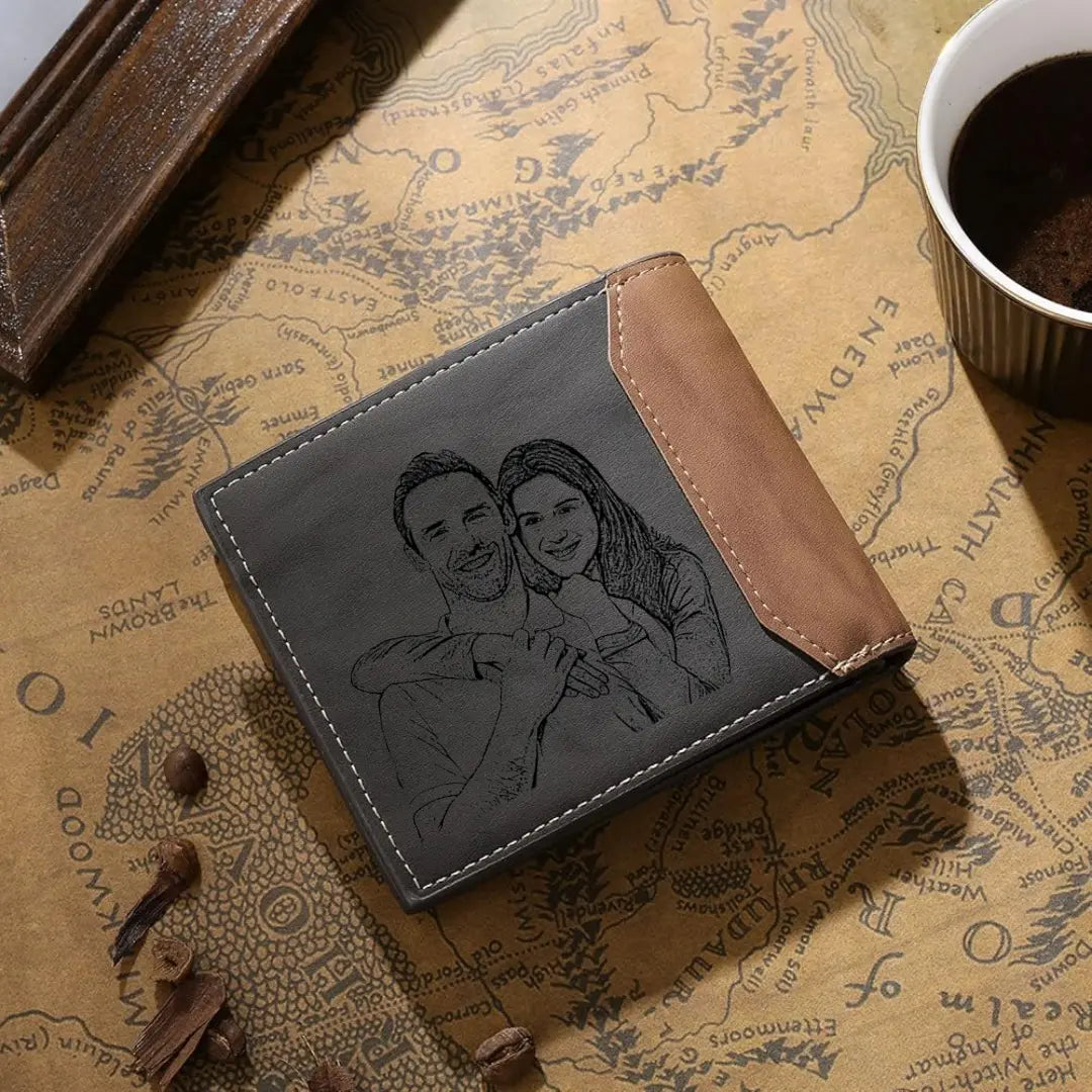 Carteira masculina de couro cinza personalizada com possibilidade de foto dupla gravada na frente e no verso, sobre mesa decorativa com café.