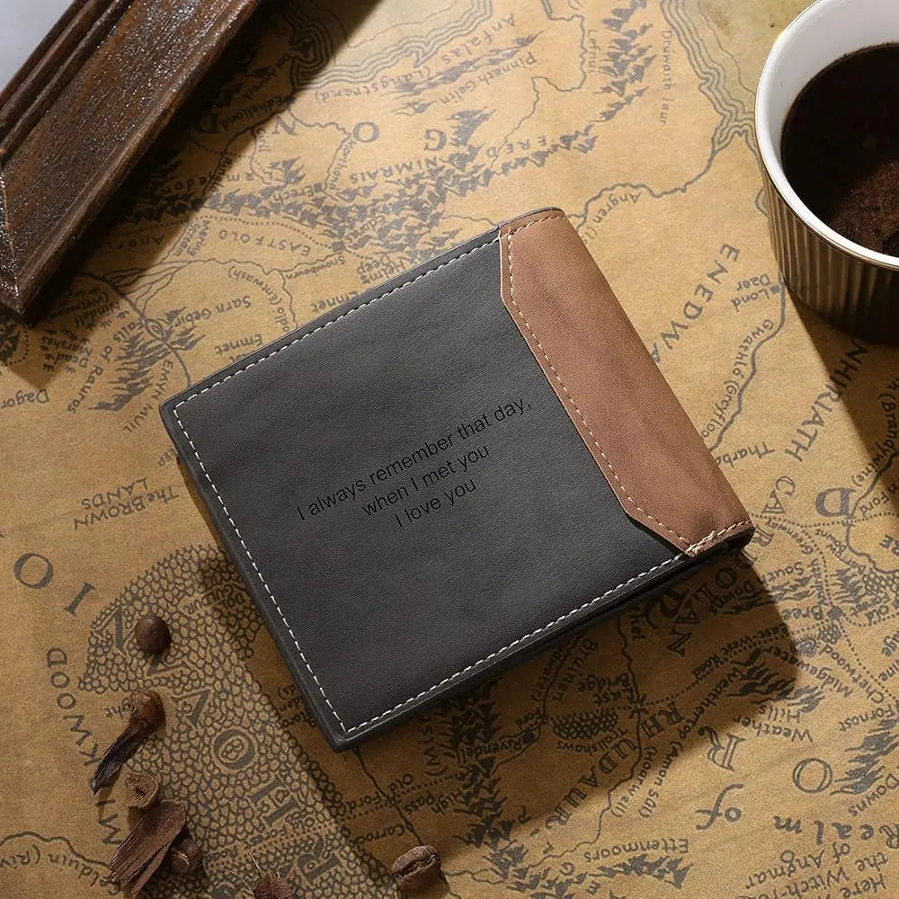 Carteira masculina de couro cinza personalizada com frase gravada, fotografada sobre fundo decorativo com café e mapa.