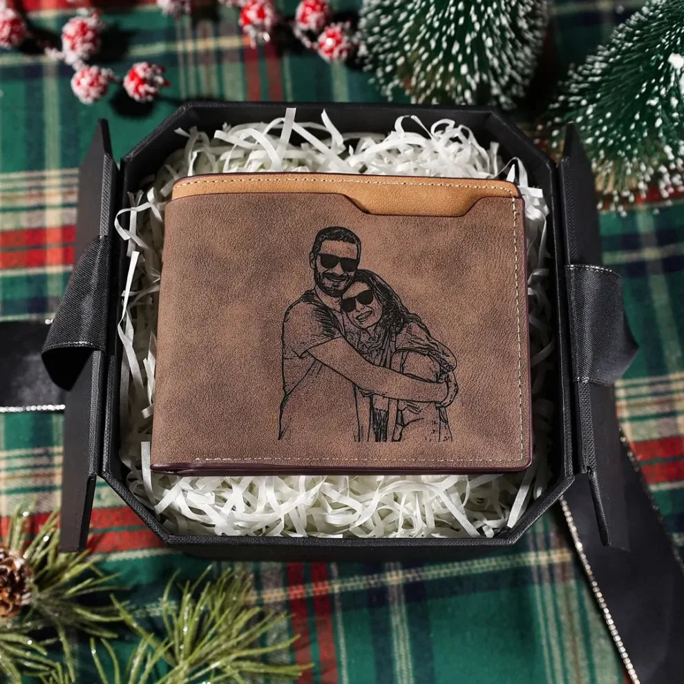 Carteira de couro masculina marrom personalizada em caixa de presente com enchimento branco, sobre fundo decorativo natalino.