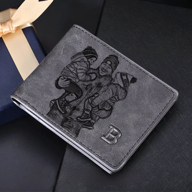 Carteira masculina de couro cinza personalizada com gravação de crianças brincando, posicionada sobre fundo escuro com caixa de presente.