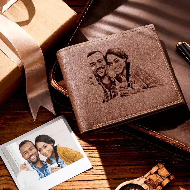 Carteira masculina de couro marrom personalizada exposta como presente, com gravação de foto de casal e caixa ao lado.