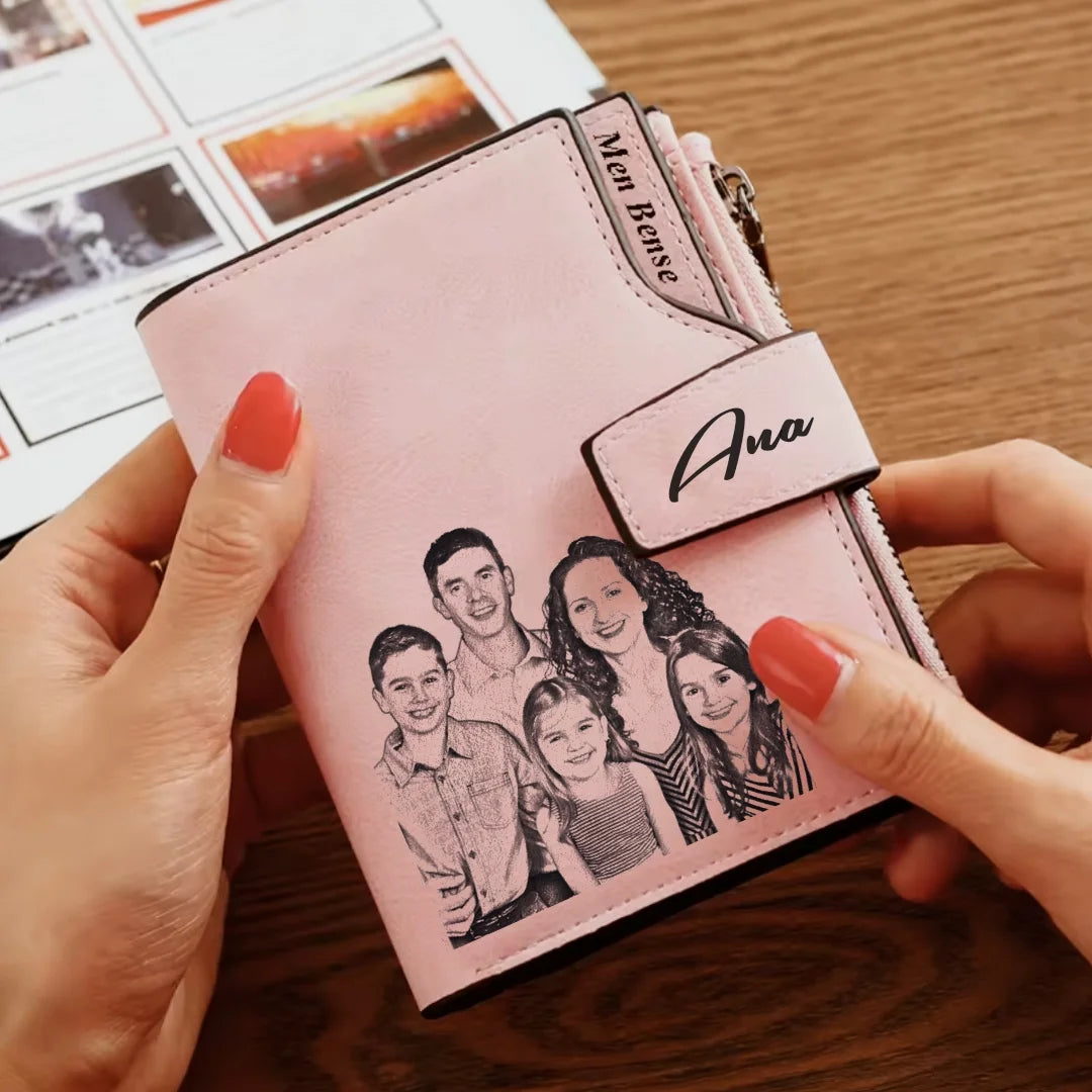 Carteira personalizada feminina rosa sendo segurada nas mãos, com foto de família impressa e nome personalizado na aba.