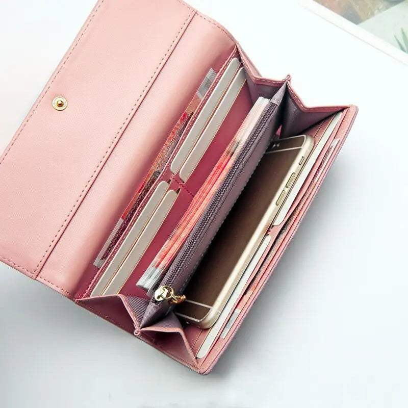 Carteira feminina rosa vista por dentro, com celular, cartões e bolso com zíper para organização.