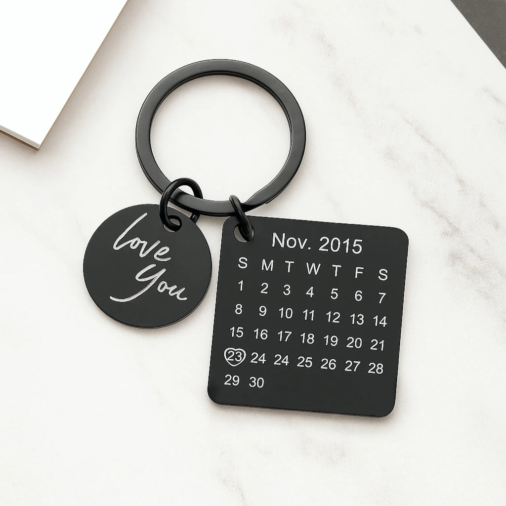 Chaveiro preto personalizado com pingente escrito love you e placa quadrada com calendário e data destacada.