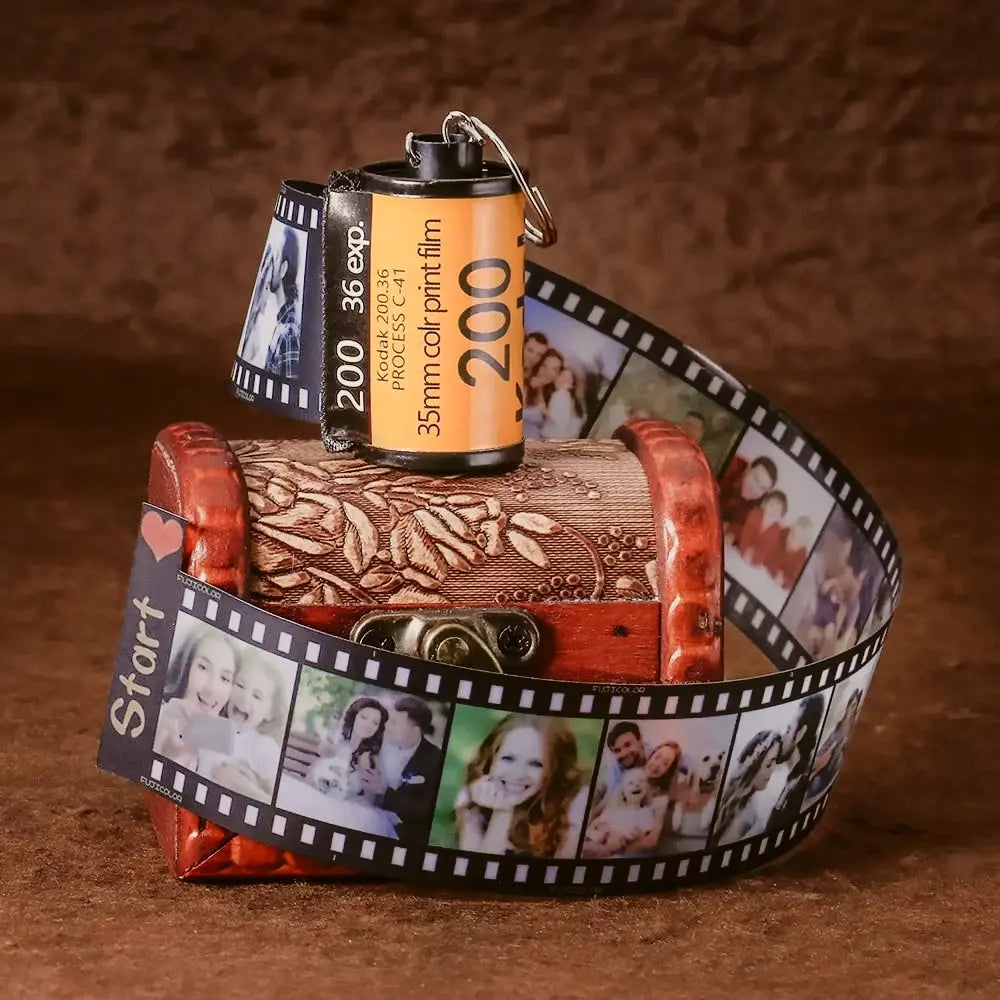 Chaveiro personalizado em formato de câmera retrô com tira de filme exibindo fotos especiais.