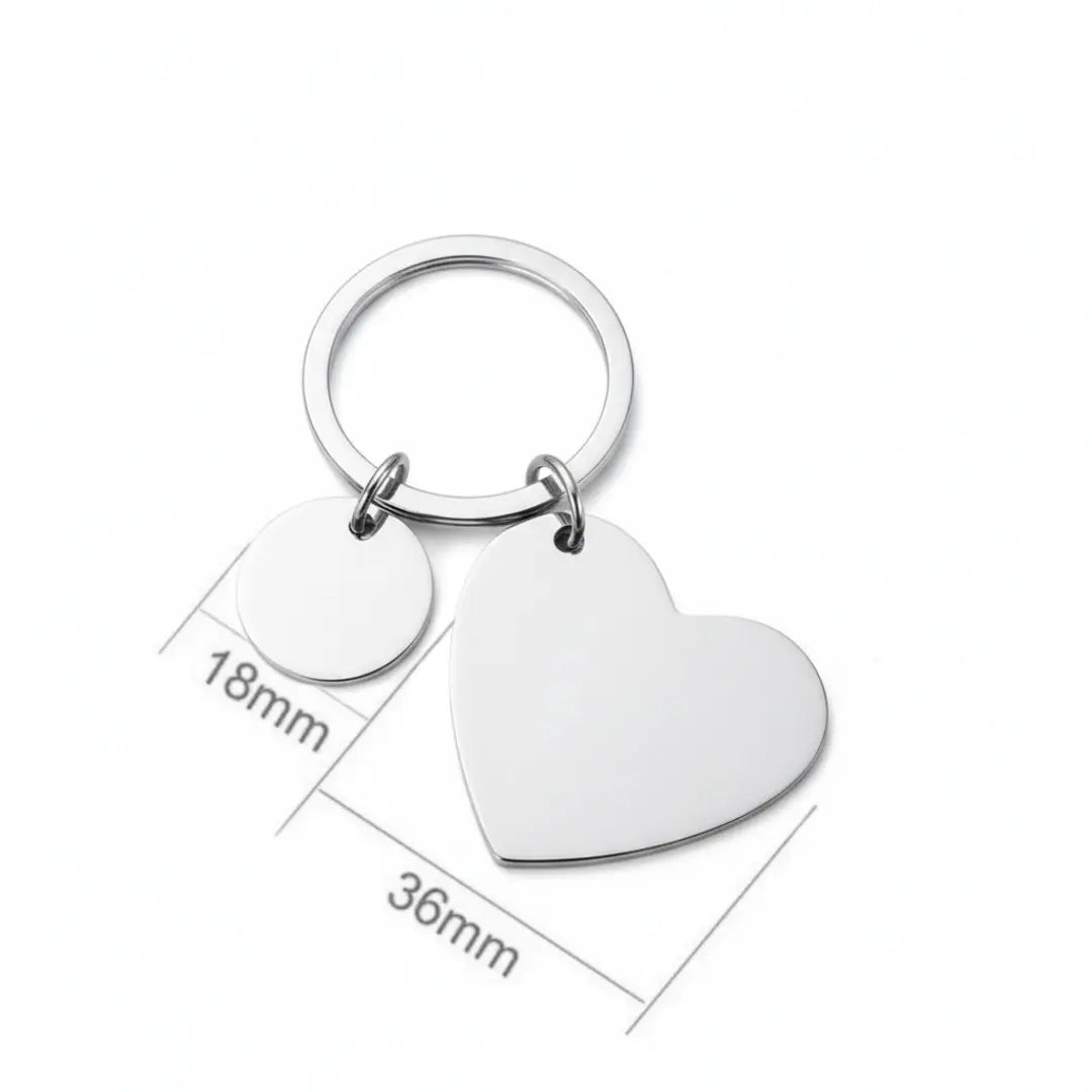 Chaveiro de coração prateado personalizado com plaqueta redonda, mostrando as medidas aproximadas das peças em fundo branco.