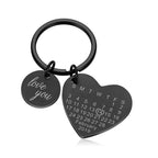 Chaveiro preto personalizado em formato de coração com pingente circular escrito love you e data gravada em calendário.