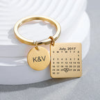 Chaveiro dourado personalizado com calendário gravado destacando data especial e pingente redondo com iniciais, em composição de apresentação de produto.