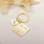 Chaveiro dourado personalizado com plaquinha quadrada, disco com nome gravado e decoração com estrela do mar ao fundo.