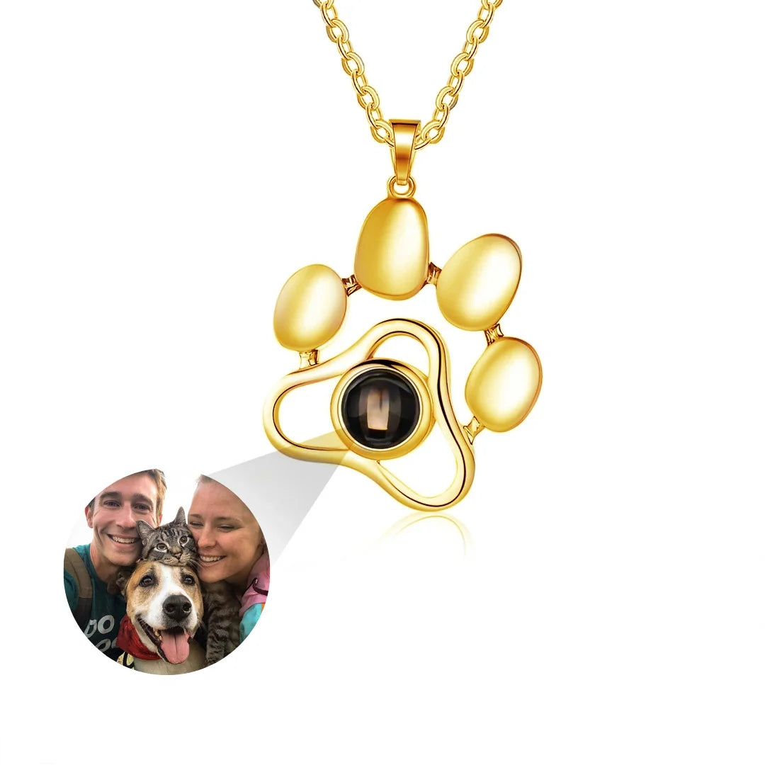 Colar dourado personalizado em formato de patinha com espaço central para foto do pet, exibido em fundo branco.