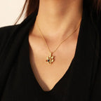 Colar dourado delicado com pingente de patinha personalizado usado sobre blusa preta.
