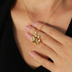 Colar personalizado dourado de patinha sendo usado no pescoço de mulher, com close do pingente de patinha em destaque.