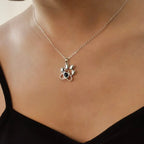 Close do colar personalizado de prata com pingente de patinha fofa no decote.