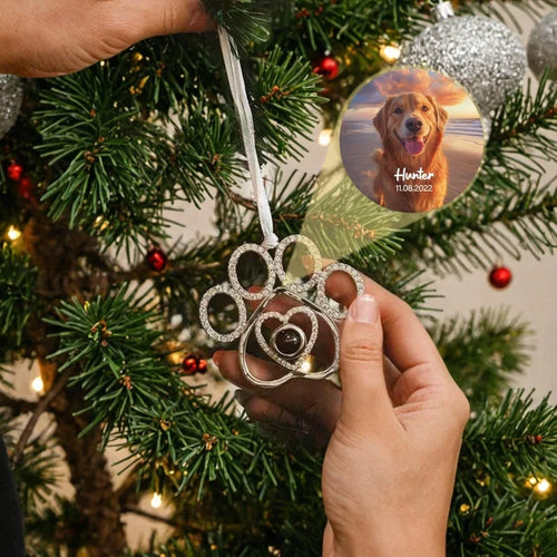 Enfeite de árvore de Natal em formato de pata de pet com foto personalizada  no centro de exemplo pendurado na árvore durante a decoração.