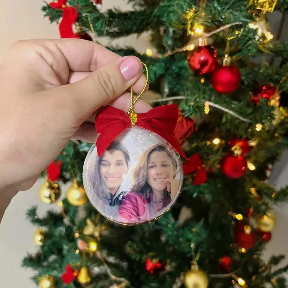 Bola para enfeitar arvore de natal personalizada com foto, exibido em close na árvore de Natal decorada.